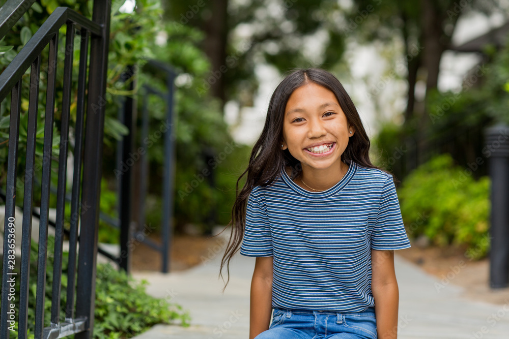 Portrait of a young Asian girl smiling outside. Portrait of a young Asian girl smiling outside.