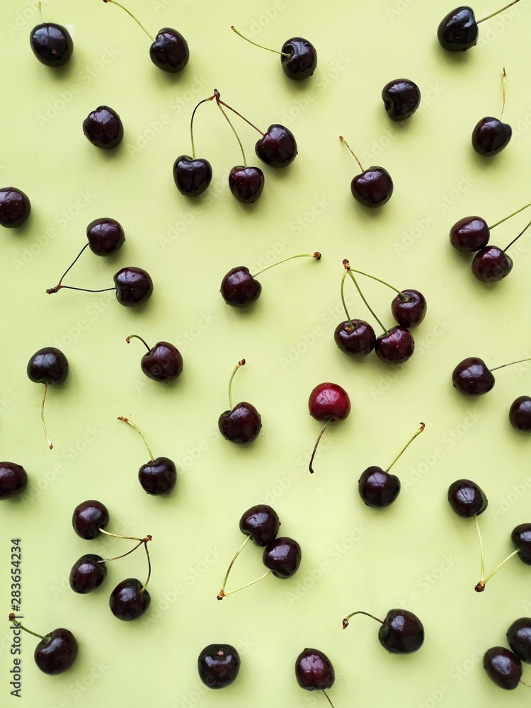 Cherry pattern on a green background flat layout top view Cherry pattern on a green background flat layout top view