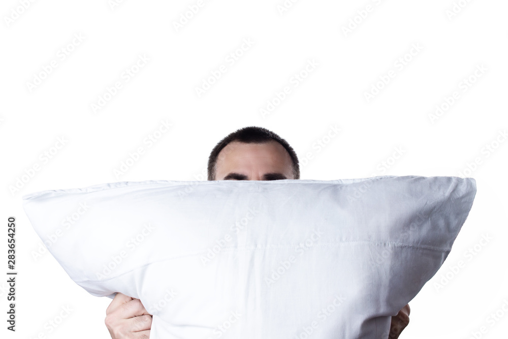 Man with pillow isolated on white background. Resting after working day or waking up in the morning. Man hiding her face behind pillow Man with pillow isolated on white background. Resting after working day or waking up in the morning. Man hiding her face behind pillow
