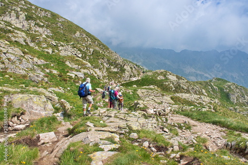 Rear view of mature and senior people hiking in Brenta Dolomites, Italy