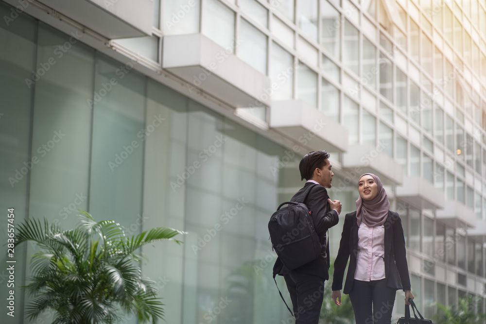 Two asian business partner walking together smiling to each other Two asian business partner walking together smiling to each other