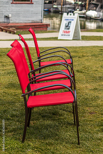 red stackable chairs in a row on grass during summer park show
