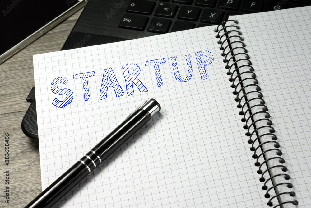 Ein Computer, Heft und Startup Ein Computer, Heft und Startup