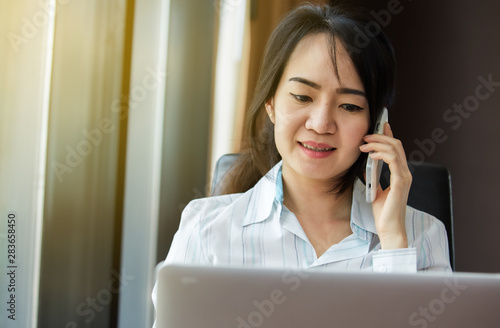 Asian busniness woman Is talking on a mobile phone photo