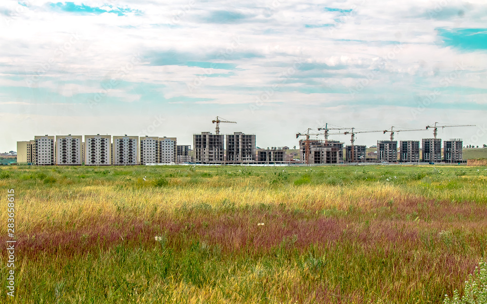 The construction of new high-rise buildings on a green field. The concept of the development of the city