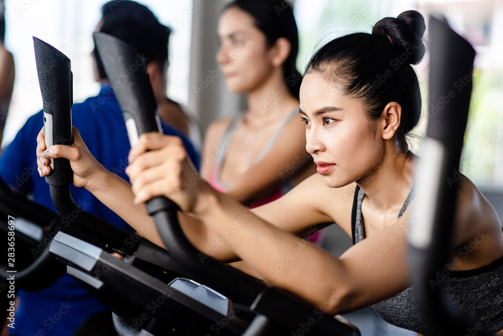 Fototapeta premium Young healthy woman bike cardio at the gym