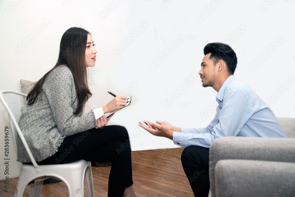 Asian male sitting on couch with Psychologist.. Asian male sitting on couch with Psychologist..