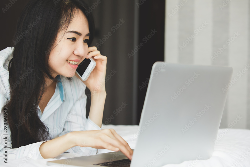 Asian business woman in smile face are using mobile phones and laptops in the office. Asian business woman in smile face are using mobile phones and laptops in the office.