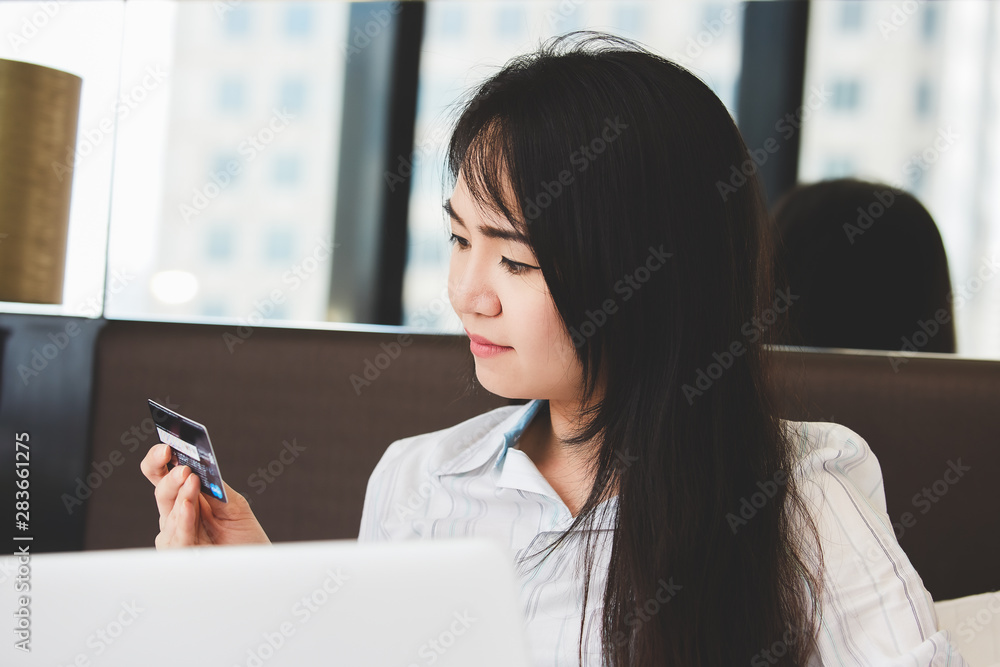 Portrait asian beautiful women are using credit cards and mobile phone to shopping online in the bedroom. Portrait asian beautiful women are using credit cards and mobile phone to shopping online in the bedroom.
