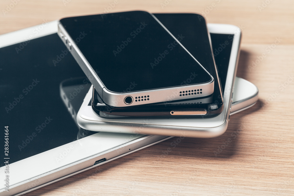 Digital tablet and mobile phone. Electronic devices on wooden table, close up. Digital tablet and mobile phone. Electronic devices on wooden table, close up.