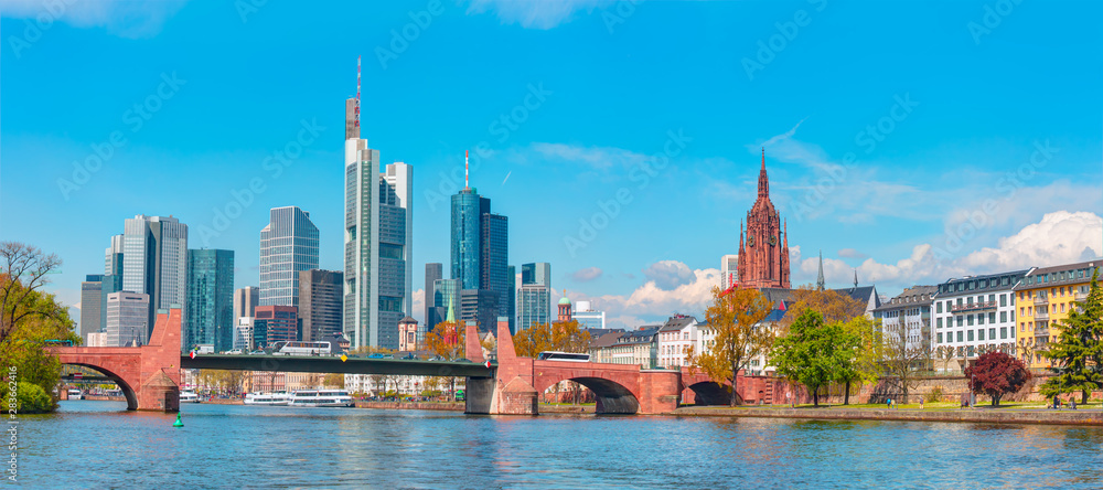 Large Cargo barge moving along the Main River with in the background beautiful view of Frankfurt am Main skyline - Frankfurt, Germany