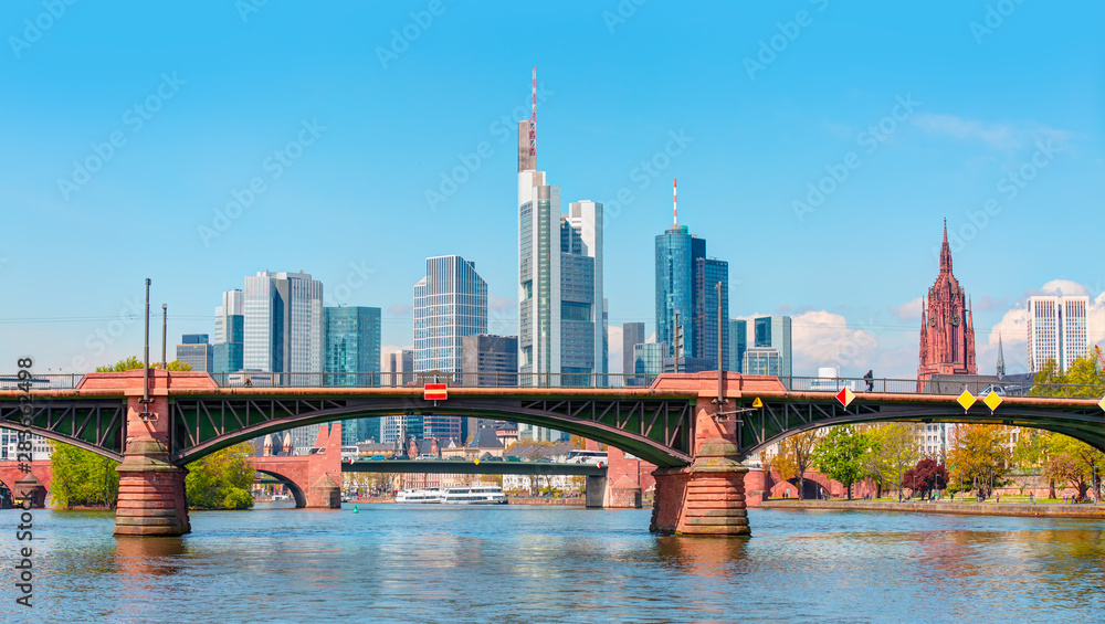 Fototapeta premium Large Cargo barge moving along the Main River with in the background beautiful view of Frankfurt am Main skyline - Frankfurt, Germany