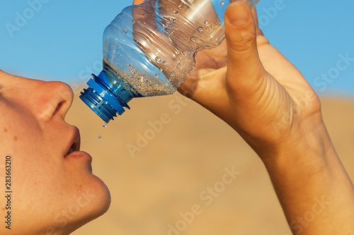 Man finishes the last water. Concept on the topic of thirst, close-up photo
