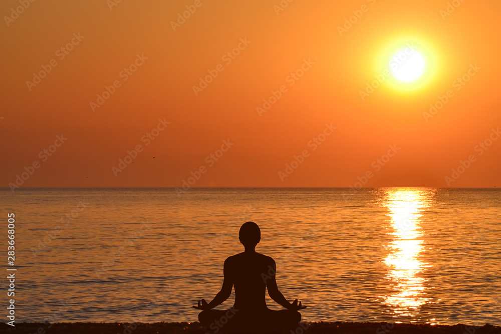 Yoga silhouette of a man sitting in lotus pose