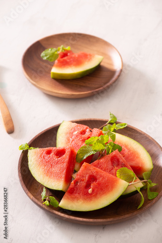 Cut slices of ripe juicy watermelon on wood plate