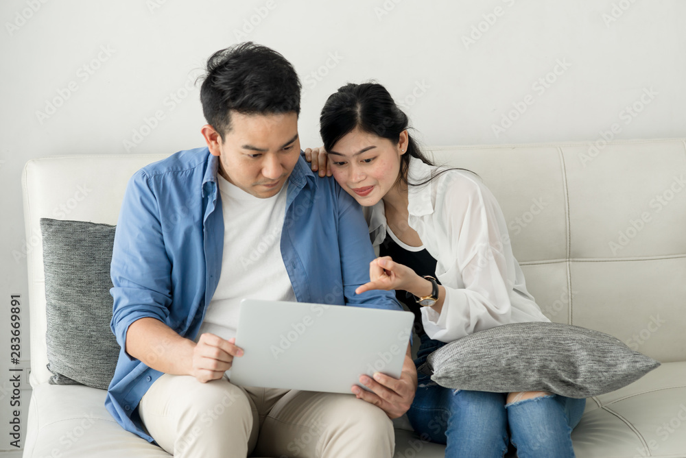 Happy Asian couple shopping online with holding credit card and laptop and sitting at home together, lifestyle concept. Happy Asian couple shopping online with holding credit card and laptop and sitting at home together, lifestyle concept.