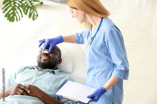 Plastic surgeon examining A...