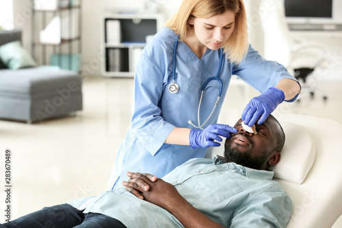 Plastic surgeon examining A...