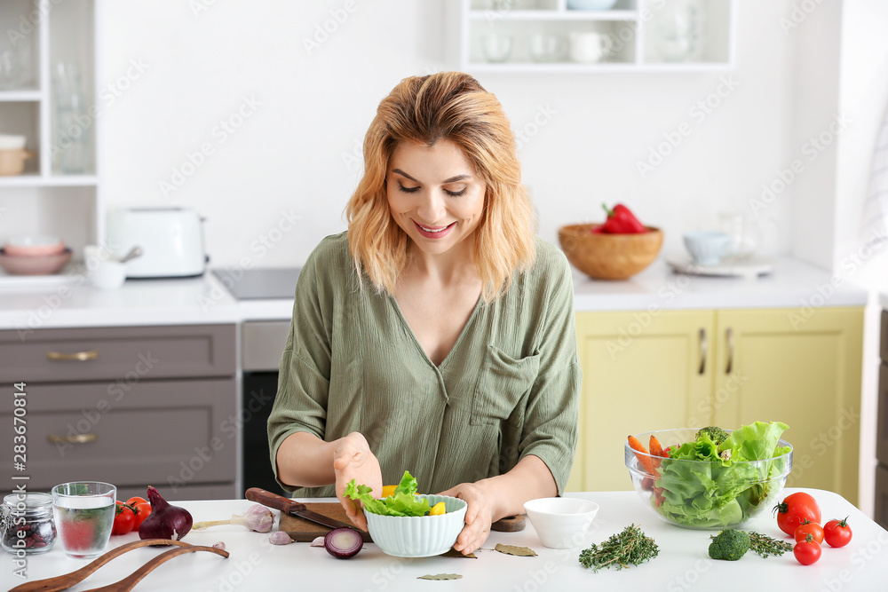 Woman making healthy vegetable salad in kitchen Woman making healthy vegetable salad in kitchen