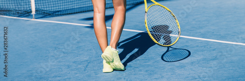 Tennis player woman shoes and racket on blue hard court background panoramic banner of athlete ready to play game. Sport exercise lifestyle. © Maridav