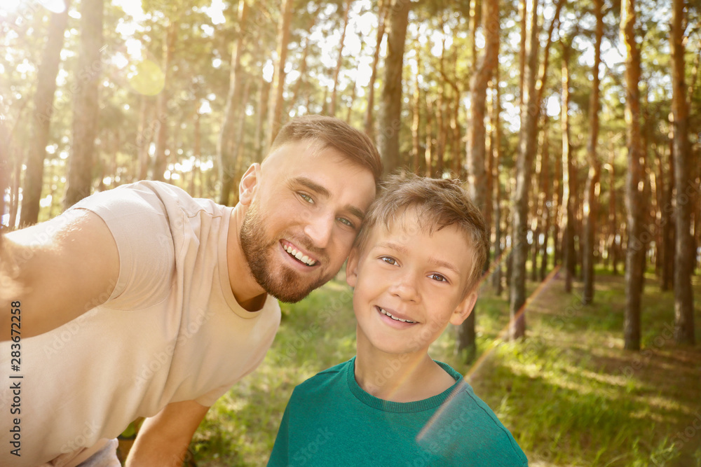Father and his little son taking selfie in forest Father and his little son taking selfie in forest