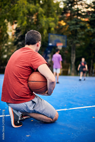 Man holding basketball ball on the urban city court.