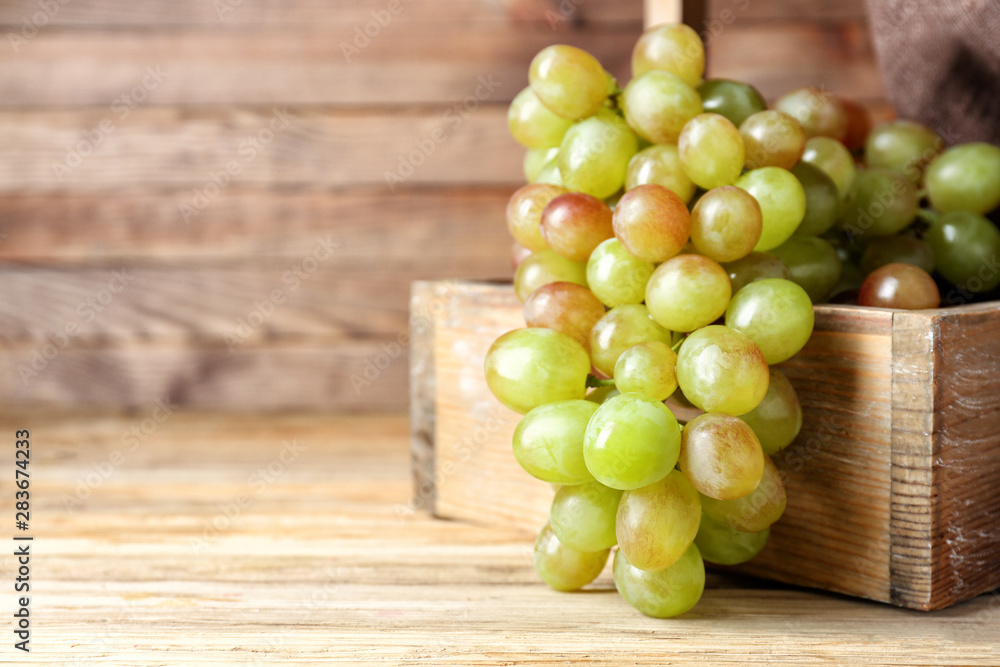 Box with tasty sweet grapes on wooden table Box with tasty sweet grapes on wooden table