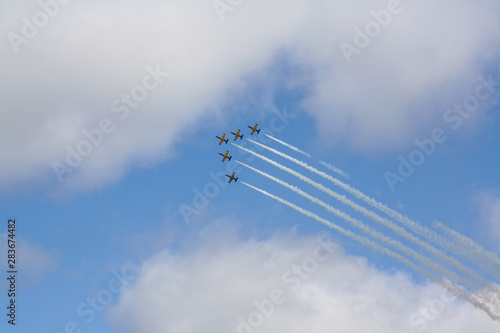 open sky air show, a group of five aircraft in the sky among the clouds