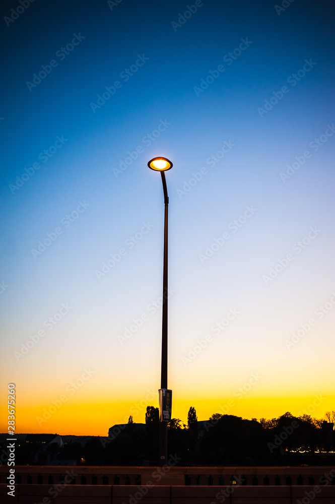 Isolated street lamp during the sunset with blue sky