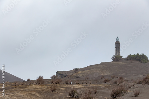 View over Capelinhos volcano, lighthouse of Ponta dos Capelinhos on western coast on Faial island, Azores, Portugal. Last volcano eruption was in 1957.