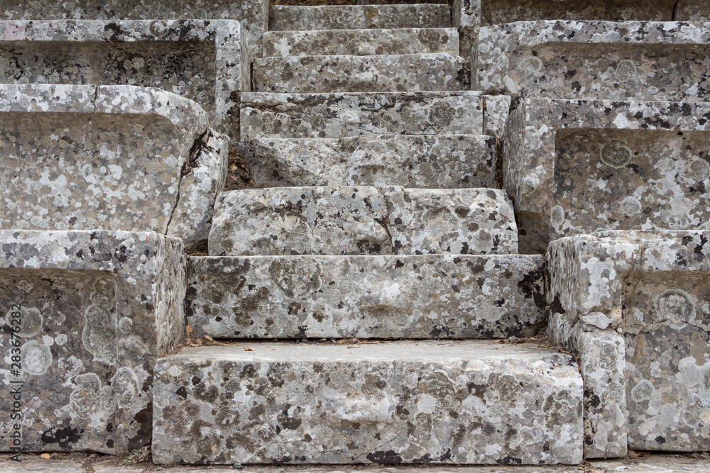 Stairs of the ancient theatre of Epidaurus in the Epidaurus town, on Peloponnesus peninsula, Greece. The theater was dedicated to the ancient Greek God of medicine, Asclepius. Stairs closeup.