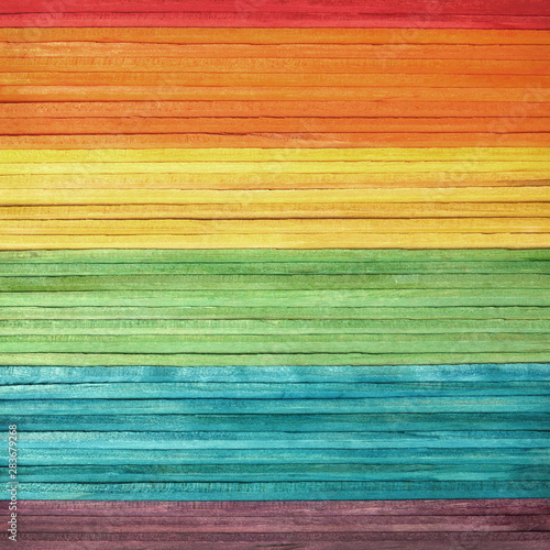 Colourful wooden wall texture in bright rainbow swatch pattern. Multicolor abstract background for banner design.