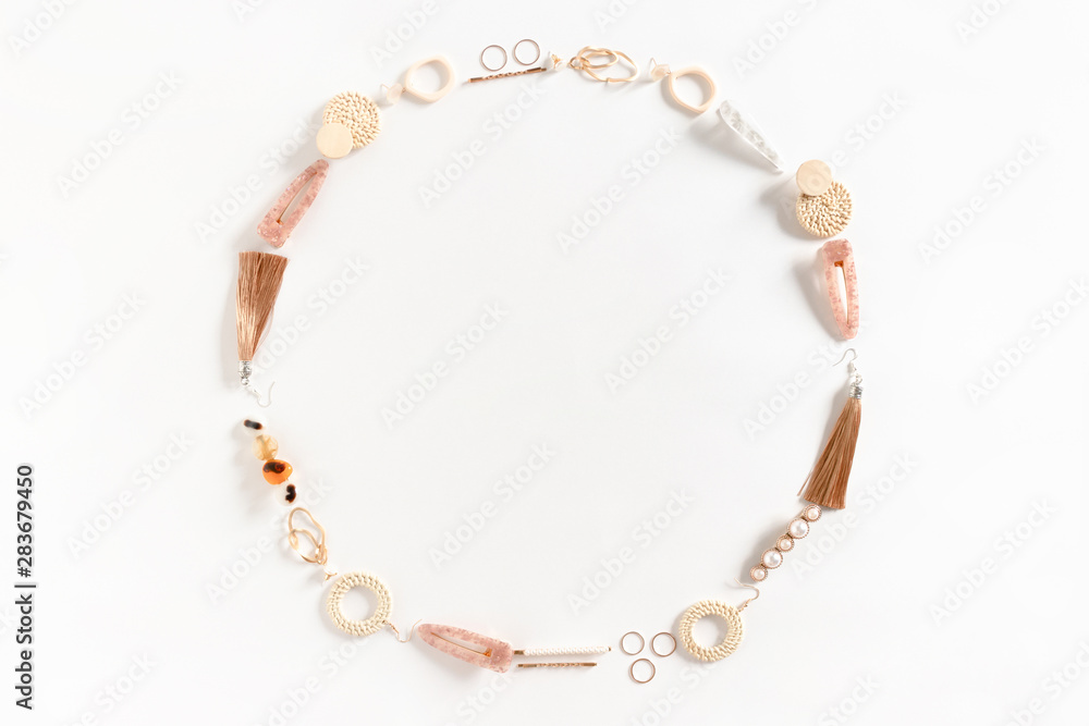 Round frame made of earrings, rings, hairpins on white background Round frame made of earrings, rings, hairpins on white background