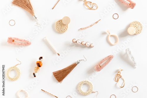 Photo Pattern made of earrings, rings, hairpins on white background