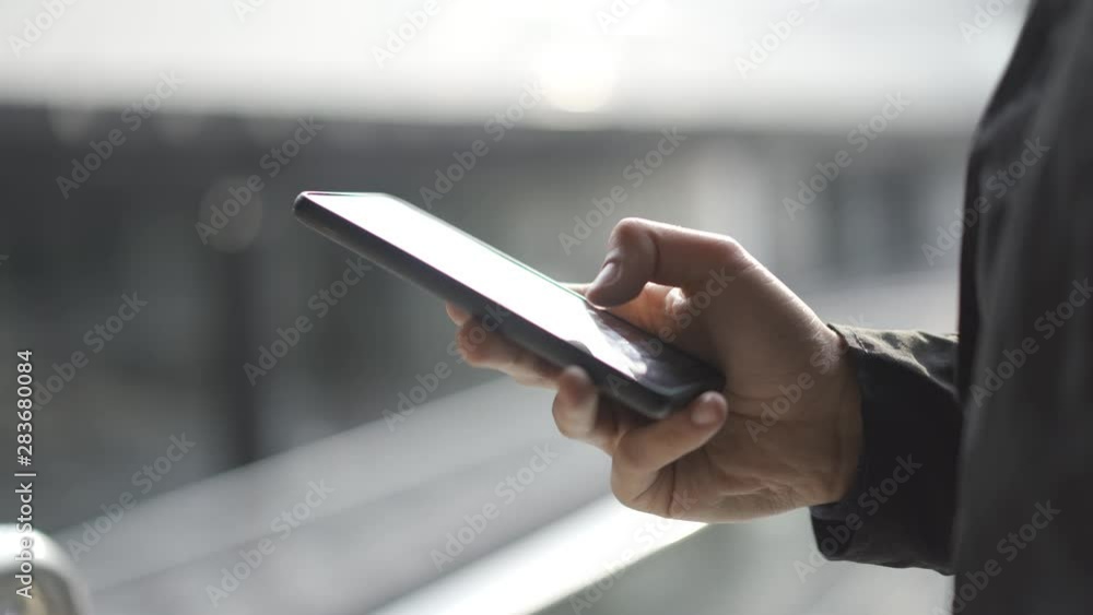 Young man using apps on a touchscreen smartphone - Concept for using technology, shopping online, using mobile apps, texting, phone addiction.