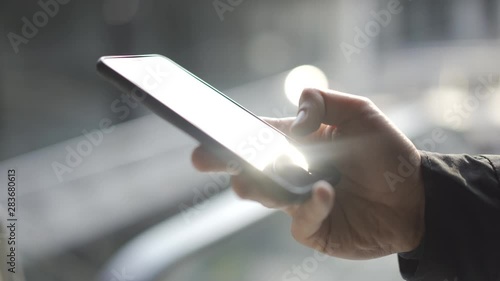 Young man using apps on a touchscreen smartphone - Concept for using technology, shopping online, using mobile apps, texting, phone addiction.