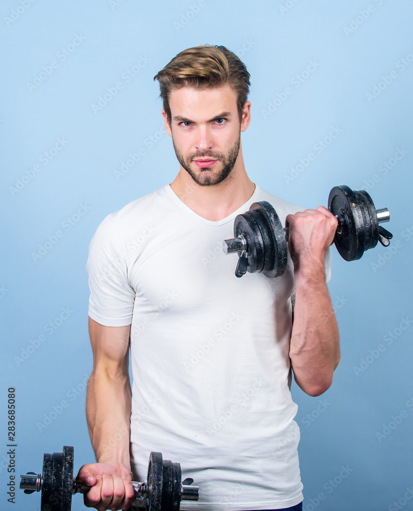 Sport equipment. Fitness and bodybuilding sport. Sport lifestyle. Sport motivation. Handsome guy workout. Exercising at gym. Muscular man exercising with dumbbell. Sportsman training strong muscles