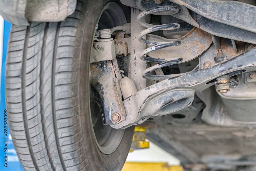 car suspension repair on a lift jack in auto service close-up car suspension repair on a lift jack in auto service close-up