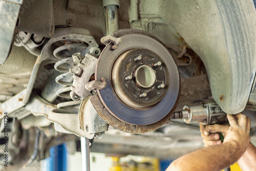 car suspension repair on a lift jack in auto service close-up