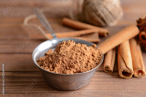 Aromatic cinnamon sticks and powder on wooden table
