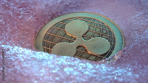 Golden Ripple coin, online digital currency frozen in the blue ice. Concept of block chain, market crash. Frozen crypto money, depreciation photo