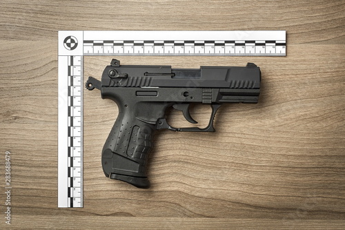 Crime Scene Investigation - handgun as a piece of evidence placed with forensic ruler for documentation