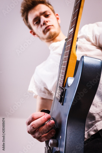 Young man is playing electric guitar