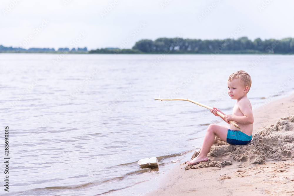 happy child fishes off the coast in nature happy child fishes off the coast in nature