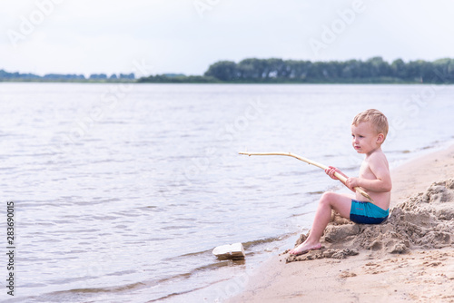 happy child fishes off the coast in nature