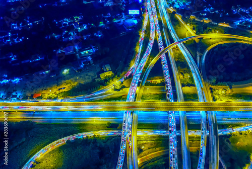 Aerial view of Circle Road traffic in roundabout and highway at night. Expressway, Modern transportation, Multilevel junction highway, Important infrastructure of transport in Thailand, Top view.