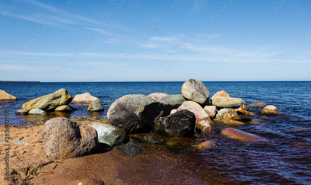 huge stones by the sea, seascape, sunny summer day, sandy beach, clear sea water