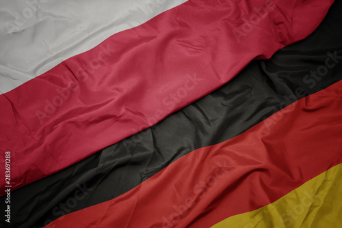 waving colorful flag of germany and national flag of poland.