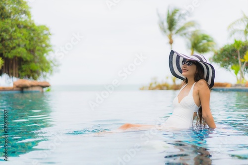 Portrait beautiful young asian woman smile happy relax around swimming pool in hotel resort © siraphol