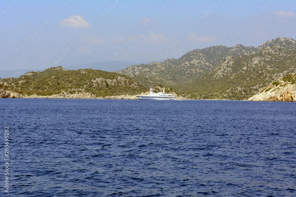 Yachts in the Mediterranean Sea on a background of rocky shores. Concept - travel by sea